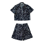 Black and white patterned shirt and shorts set on a white background