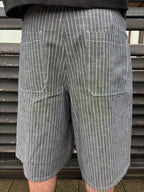 Person wearing gray pinstripe shorts with a blurred background