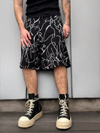 Person wearing a black and white patterned skirt with high-top sneakers against a plain background