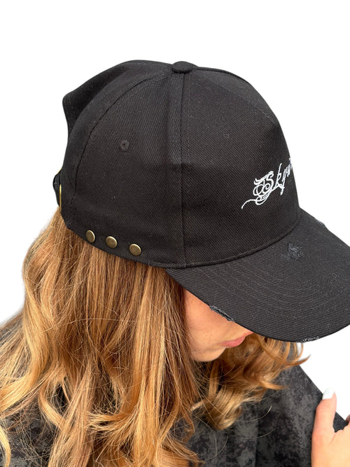 Person wearing a black cap with a logo, on a white background