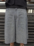 Person wearing gray checkered shorts with a black top against a metallic background