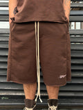 Person wearing brown shorts with a visible brand logo on a metal staircase background