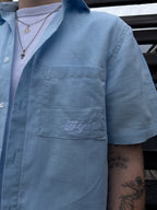 Close-up of a light blue shirt with embroidery on a person wearing it.