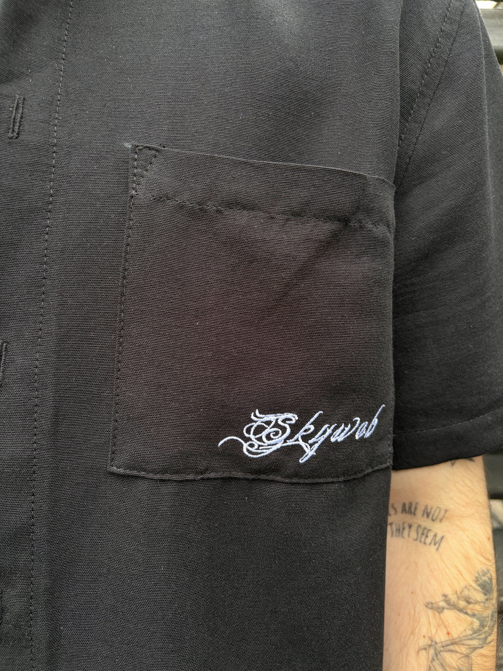 Black shirt with 'Skyweb' logo on chest pocket