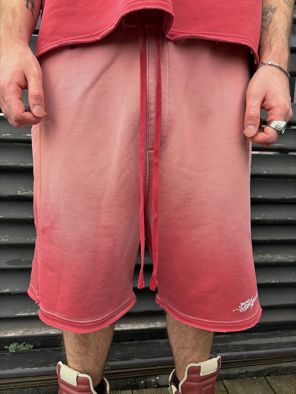 Person wearing red shorts and a red shirt on a metal staircase.