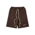 Brown shorts with white drawstring and branding on a white background
