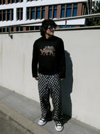 SKYWEB baggy black and white checkerboard denim jeans with frayed texture worn by a model in an urban setting