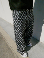 SKYWEB baggy black and white checkerboard denim jeans with raised frayed texture and a relaxed streetwear fit.