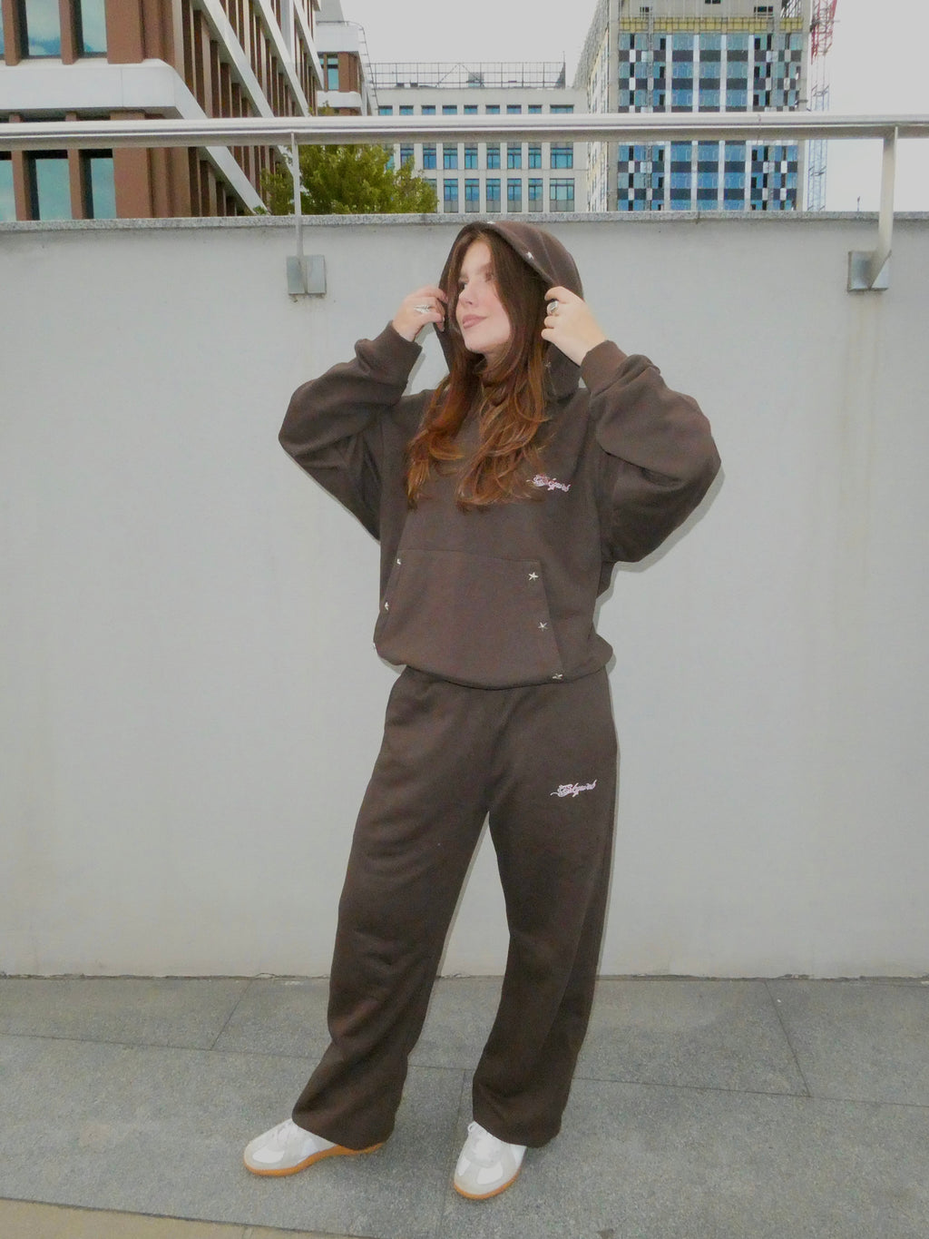 SKYWEB oversized rust hoodie and matching sweatpants with silver star studs and embroidered logo on a female model