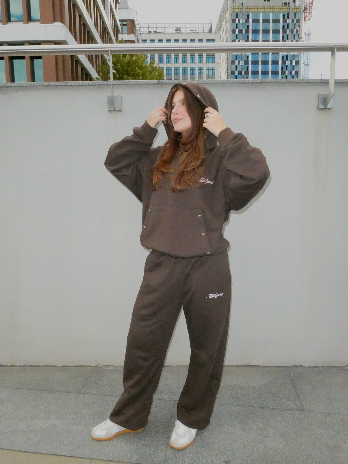 SKYWEB oversized rust hoodie and matching sweatpants with silver star studs and embroidered logo on a female model