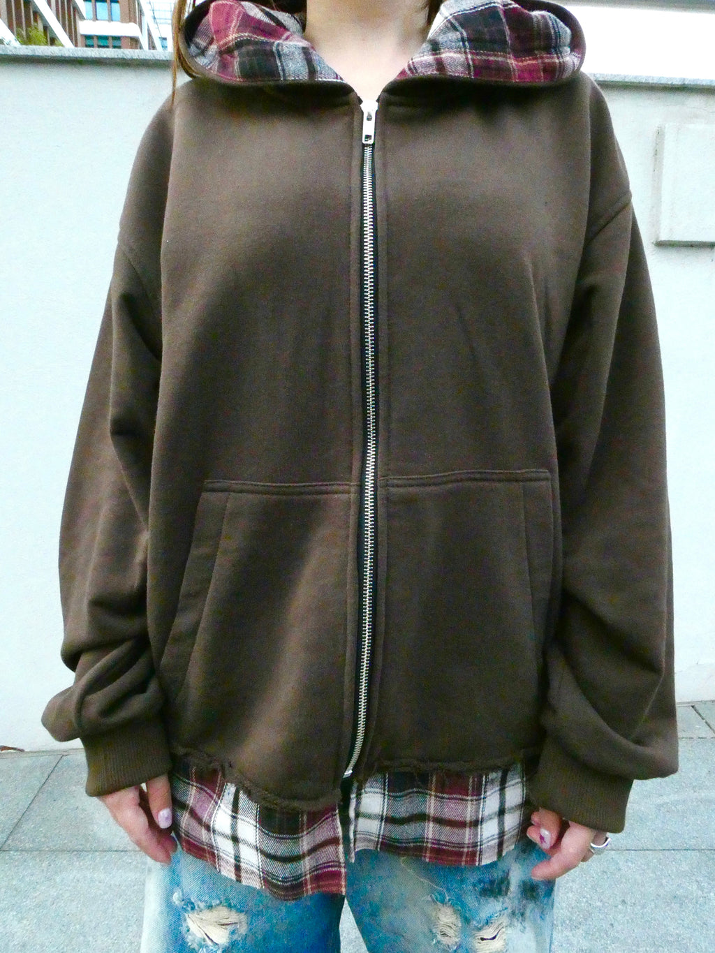 SKYWEB rust oversized zip-up hoodie featuring a patchwork plaid flannel hood lining and extended hem with raw seams.