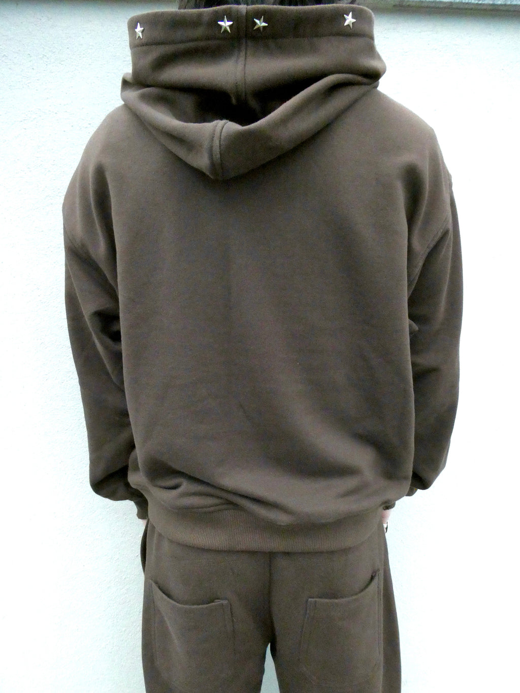 SKYWEB rust oversized hoodie with silver star studs along the hood opening, viewed from the back
