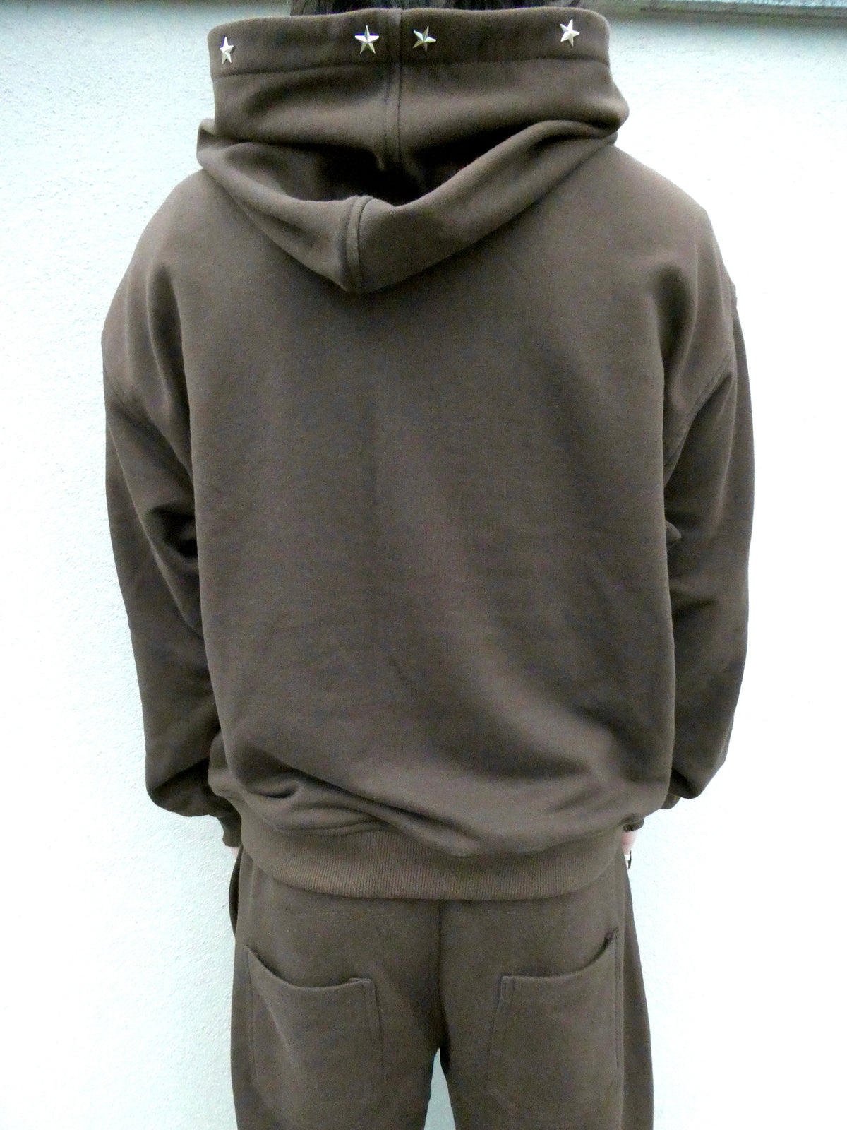 SKYWEB rust oversized hoodie with silver star studs along the hood opening, viewed from the back